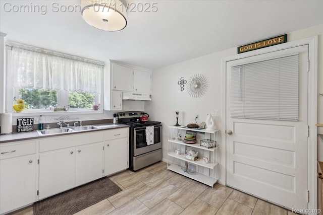 1338 W King St, Owosso, MI 48867 - kitchen featuring stainless steel electric stove, white cabinets, and under cabinet range hood
