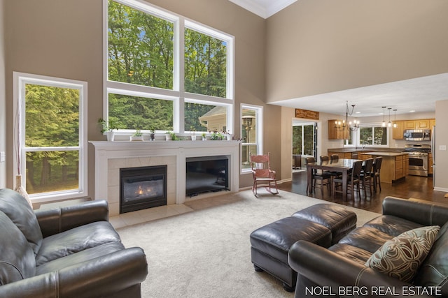 13462 Ravine View Dr, Grand Haven, MI 49417 - living room with a tiled fireplace, a chandelier, a towering ceiling, and ornamental molding