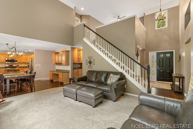 13462 Ravine View Dr, Grand Haven, MI 49417 - living area featuring a chandelier, a towering ceiling, stairs, dark carpet, and recessed lighting