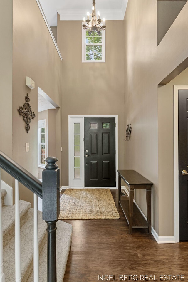 13462 Ravine View Dr, Grand Haven, MI 49417 - entrance foyer featuring a chandelier, dark wood-style floors, ornamental molding, stairs, and a towering ceiling