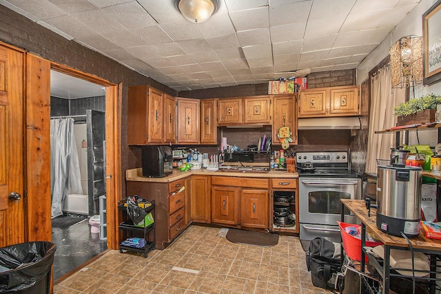 54 Wren St, Battle Creek, MI 49017 - kitchen featuring electric stove, light countertops, under cabinet range hood, and brown cabinetry
