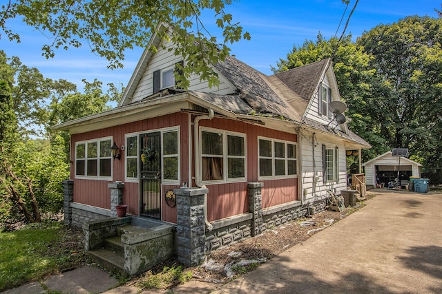54 Wren St, Battle Creek, MI 49017 - view of front of house with entry steps, roof with shingles, an outdoor structure, and a detached garage
