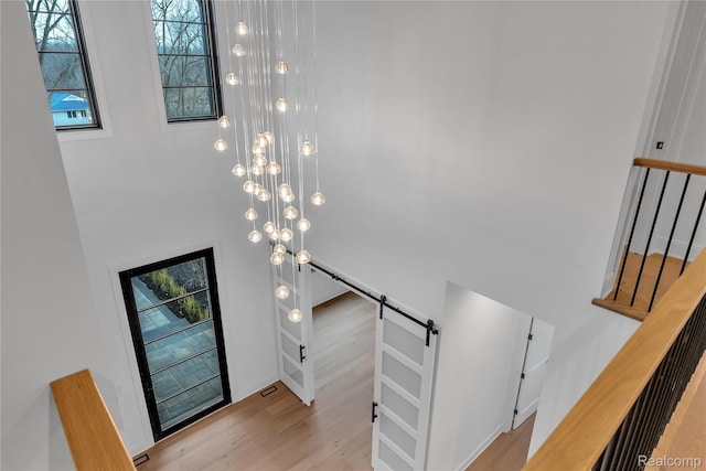 4627 Cimarron Dr, Bloomfield Hills, MI 48302 - staircase with a barn door, a towering ceiling, wood finished floors, and healthy amount of natural light