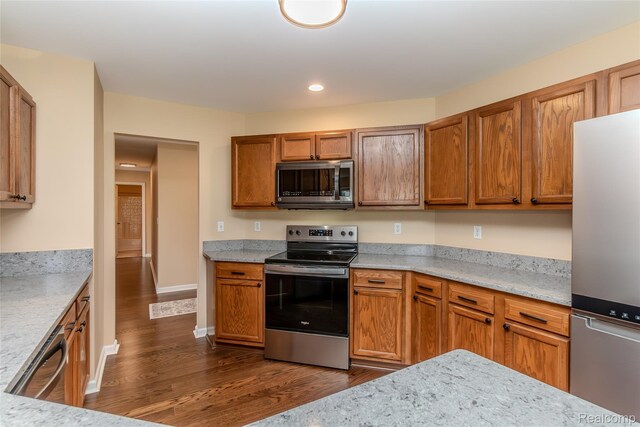 16017 Whippoorwill Ct, Manchester, MI 48158 - kitchen with appliances with stainless steel finishes, dark wood finished floors, brown cabinetry, recessed lighting, and light stone counters