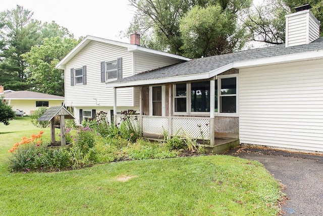 12345 Beadle Lake Rd, Battle Creek, MI 49014 - view of front of property with a chimney, a front yard, and a shingled roof