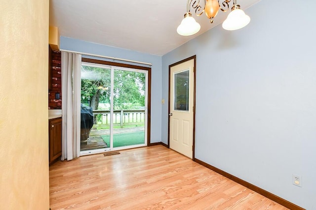 12345 Beadle Lake Rd, Battle Creek, MI 49014 - unfurnished room featuring a chandelier and light wood-style flooring