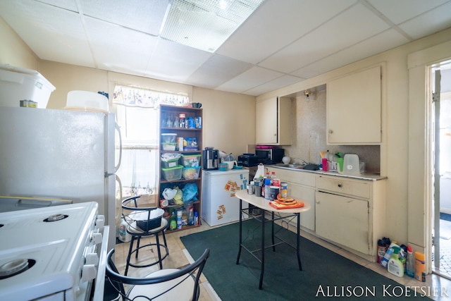 945 Kalamazoo Ave SE, Grand Rapids, MI 49507 - kitchen featuring white appliances, a paneled ceiling, and light countertops
