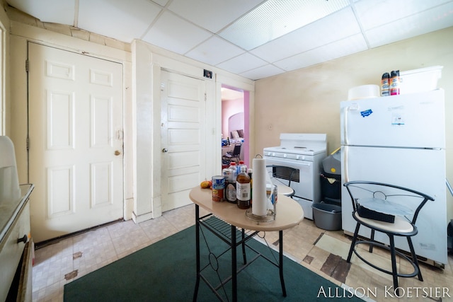 945 Kalamazoo Ave SE, Grand Rapids, MI 49507 - kitchen with white appliances, a drop ceiling, and tile patterned flooring