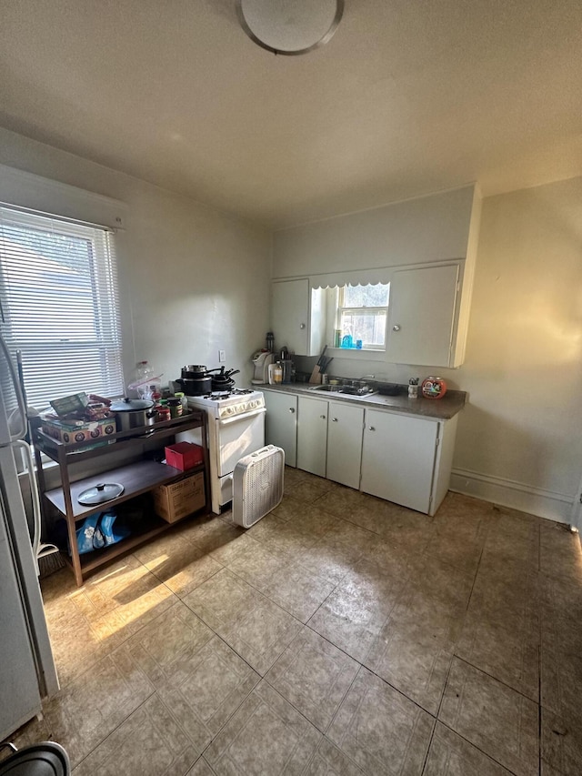 945 Kalamazoo Ave SE, Grand Rapids, MI 49507 - kitchen with white cabinets, gas range gas stove, and light tile patterned flooring
