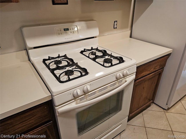 4866 Elm Tree Ln, Warren, MI 48092 - kitchen featuring white appliances, light countertops, light tile patterned flooring, and dark brown cabinetry