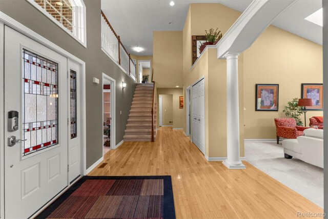 24065 Timber Creek Ln, Flat Rock, MI 48134 - entryway with ornate columns, a towering ceiling, wood-type flooring, recessed lighting, and stairway