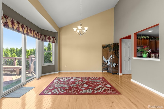 24065 Timber Creek Ln, Flat Rock, MI 48134 - unfurnished dining area with a chandelier, light wood-style flooring, and high vaulted ceiling