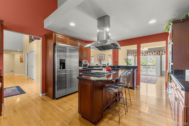 24065 Timber Creek Ln, Flat Rock, MI 48134 - kitchen featuring appliances with stainless steel finishes, island exhaust hood, a kitchen breakfast bar, a center island, and light wood-style floors