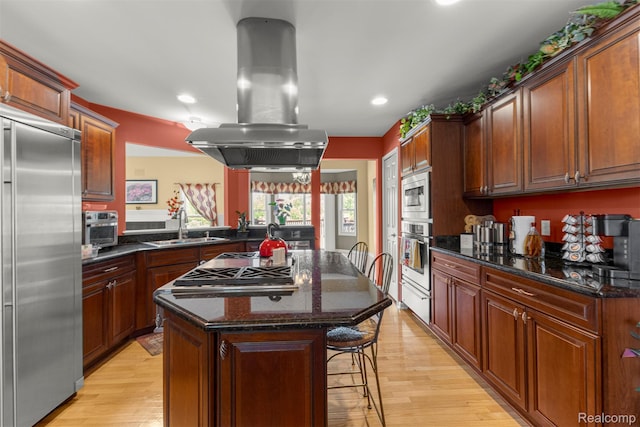 24065 Timber Creek Ln, Flat Rock, MI 48134 - kitchen with appliances with stainless steel finishes, island range hood, a center island, a breakfast bar area, and recessed lighting