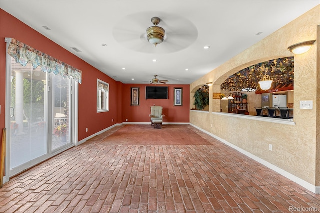 24065 Timber Creek Ln, Flat Rock, MI 48134 - unfurnished living room featuring brick floors, a ceiling fan, recessed lighting, and a textured wall