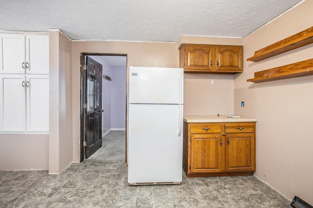 404 Susan Ave, Sturgis, MI 49091 - kitchen with freestanding refrigerator, brown cabinetry, a textured ceiling, light countertops, and open shelves