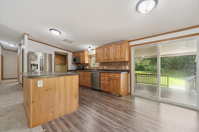 19905 N Ave, Battle Creek, MI 49017 - kitchen featuring stainless steel appliances, dark countertops, a center island, vaulted ceiling, and a textured ceiling