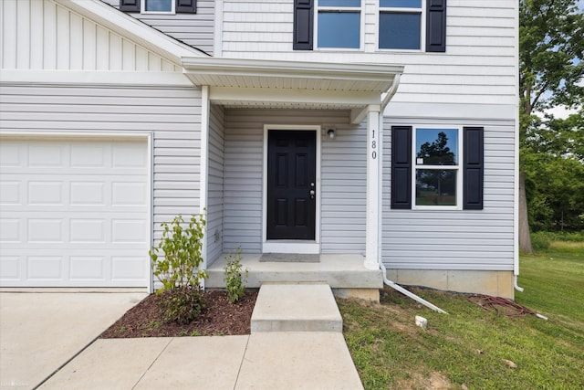 180 Ash St, Corunna, MI 48817 - entrance to property featuring board and batten siding, a garage, a yard, and driveway