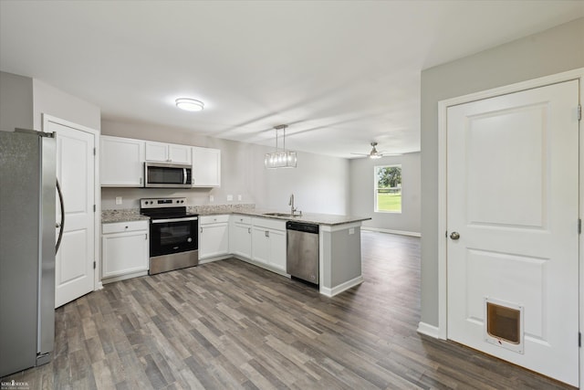 180 Ash St, Corunna, MI 48817 - kitchen with appliances with stainless steel finishes, white cabinets, a peninsula, and dark wood finished floors