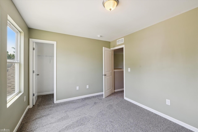 180 Ash St, Corunna, MI 48817 - unfurnished bedroom with a walk in closet and carpet flooring