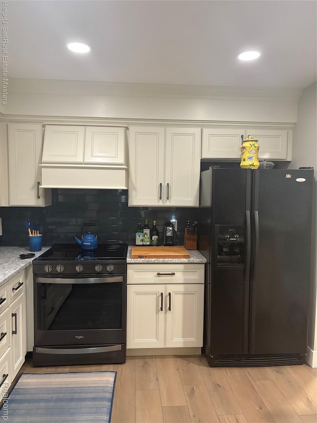 1975 Michigan Ave Unit 47, Marysville, MI 48040 - kitchen featuring black fridge with ice dispenser, range with gas cooktop, white cabinets, decorative backsplash, and crown molding