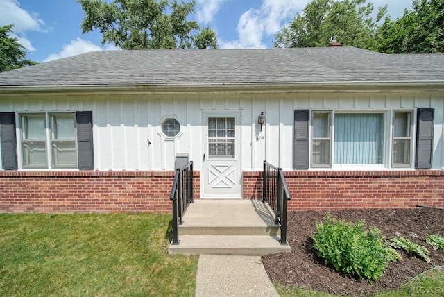 608 Brook St, Tecumseh, MI 49286 - view of front of house with brick siding, roof with shingles, board and batten siding, and a front yard