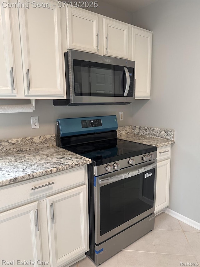 820 Woodhaven Dr, Commerce Twp, MI 48390 - kitchen with appliances with stainless steel finishes, white cabinetry, light tile patterned floors, and light stone countertops