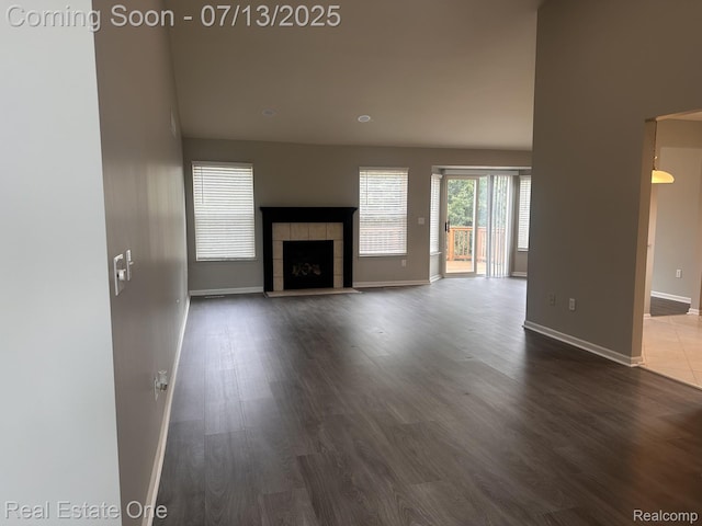 820 Woodhaven Dr, Commerce Twp, MI 48390 - unfurnished living room featuring dark wood-style flooring and a tiled fireplace