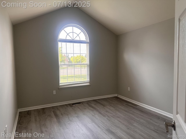 820 Woodhaven Dr, Commerce Twp, MI 48390 - empty room with dark wood finished floors, plenty of natural light, and lofted ceiling