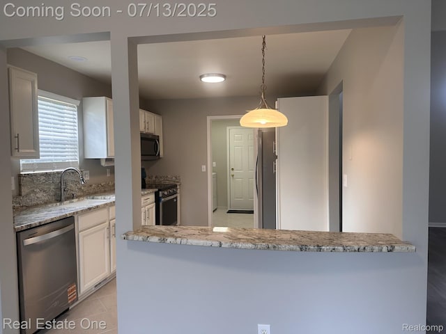 820 Woodhaven Dr, Commerce Twp, MI 48390 - kitchen with appliances with stainless steel finishes, white cabinetry, light stone countertops, and pendant lighting