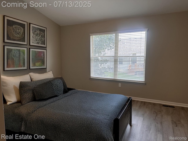 820 Woodhaven Dr, Commerce Twp, MI 48390 - bedroom featuring wood finished floors and lofted ceiling