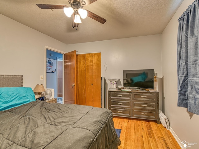 1405 Arbor Ave, Monroe, MI 48162 - bedroom with light wood-type flooring, baseboard heating, a closet, a textured ceiling, and a ceiling fan