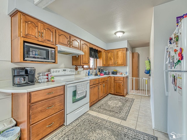1405 Arbor Ave, Monroe, MI 48162 - kitchen featuring white appliances, under cabinet range hood, brown cabinetry, light countertops, and a textured ceiling