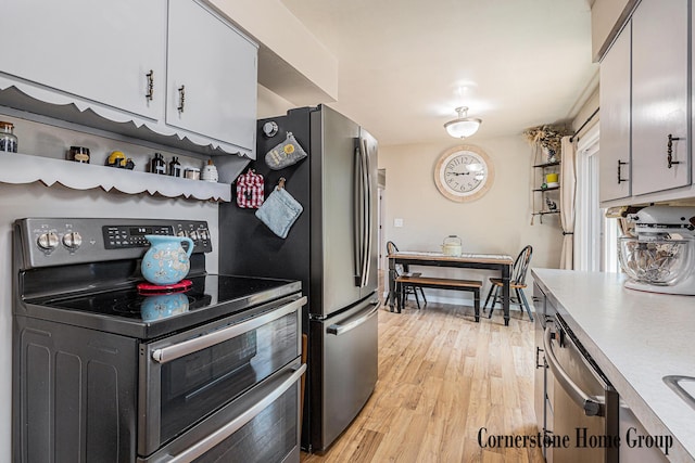 8611 Byron Center Ave SW, Byron Center, MI 49315 - kitchen featuring appliances with stainless steel finishes, light countertops, light wood-style floors, and white cabinets