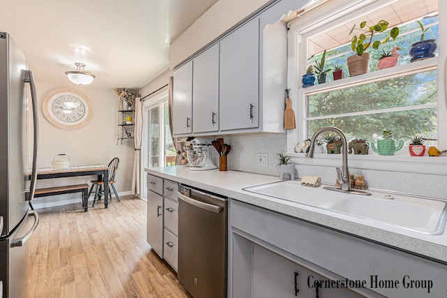 8611 Byron Center Ave SW, Byron Center, MI 49315 - kitchen with appliances with stainless steel finishes, gray cabinetry, light countertops, and light wood-type flooring