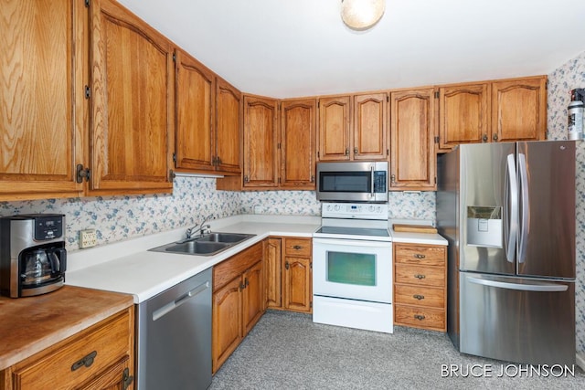 1236 S Van Bruggen Dr, Plainwell, MI 49080 - kitchen featuring appliances with stainless steel finishes, brown cabinetry, light countertops, and light colored carpet