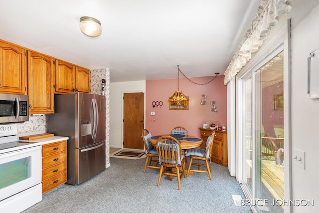 1236 S Van Bruggen Dr, Plainwell, MI 49080 - kitchen with appliances with stainless steel finishes, light carpet, brown cabinetry, and light countertops