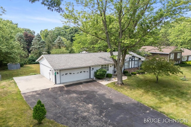 1236 S Van Bruggen Dr, Plainwell, MI 49080 - view of front of home with a front lawn, driveway, an attached garage, and a storage shed