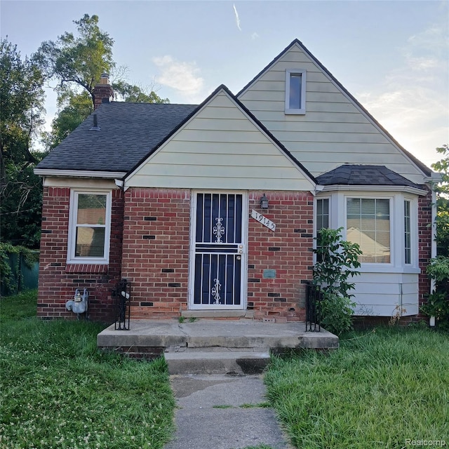 19145 Fielding St, Detroit, MI 48219 - bungalow with brick siding, a chimney, a shingled roof, and a front yard