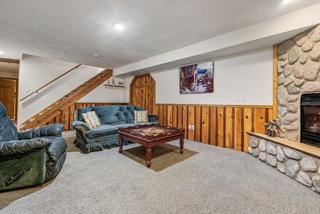 16253 1st Ln, Union Pier, MI 49129 - carpeted living area featuring a textured ceiling, wainscoting, wooden walls, stairs, and a fireplace