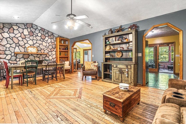 16253 1st Ln, Union Pier, MI 49129 - living area featuring lofted ceiling, arched walkways, healthy amount of natural light, a ceiling fan, and wood-type flooring