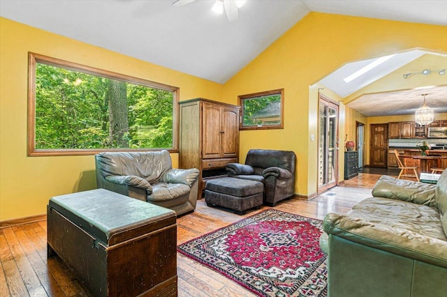 16253 1st Ln, Union Pier, MI 49129 - living room with wood-type flooring, lofted ceiling, ceiling fan, a skylight, and a chandelier