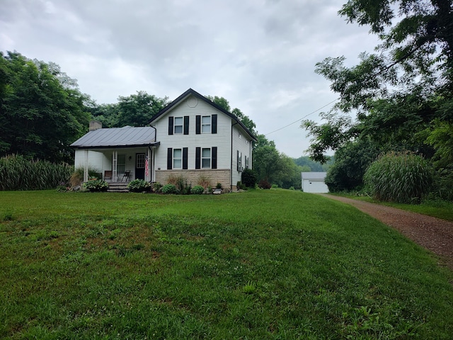 411 Block Rd, Coldwater, MI 49036 - view of front of property featuring covered porch, a front lawn, stone siding, and a chimney