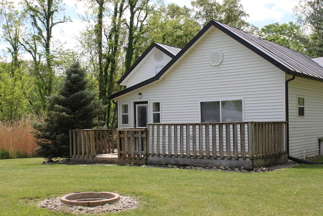 411 Block Rd, Coldwater, MI 49036 - rear view of house featuring a wooden deck, a lawn, and an outdoor fire pit