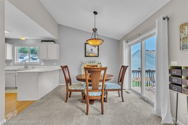 77 Sedum, Howell, MI 48843 - dining room featuring vaulted ceiling, light wood-style flooring, and light carpet