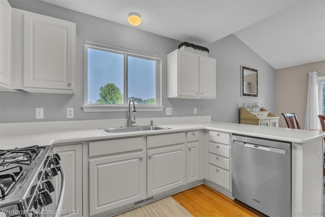 77 Sedum, Howell, MI 48843 - kitchen featuring appliances with stainless steel finishes, healthy amount of natural light, white cabinets, light countertops, and vaulted ceiling
