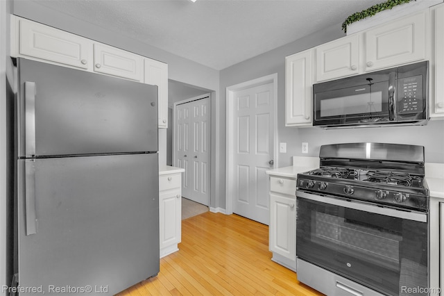 77 Sedum, Howell, MI 48843 - kitchen with black appliances, light countertops, white cabinetry, and light wood-style floors