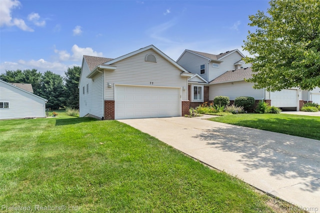 77 Sedum, Howell, MI 48843 - traditional home with an attached garage, a front yard, concrete driveway, and brick siding