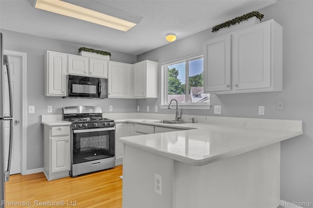 77 Sedum, Howell, MI 48843 - kitchen with appliances with stainless steel finishes, a peninsula, light wood-type flooring, white cabinets, and light countertops