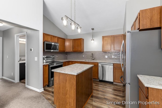 1026 Coldbrook St NE, Grand Rapids, MI 49503 - kitchen featuring stainless steel appliances, brown cabinets, decorative backsplash, vaulted ceiling, and a center island
